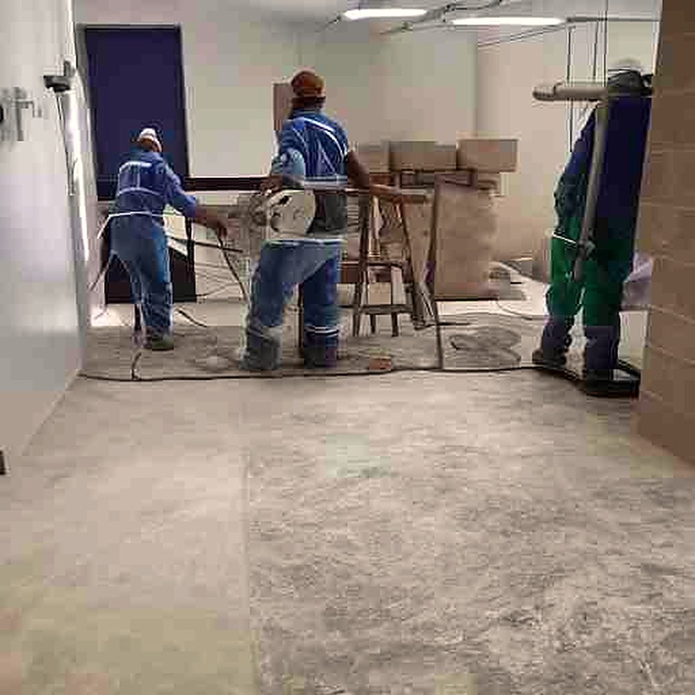 Workers cutting engineered stone in a dusty workshop